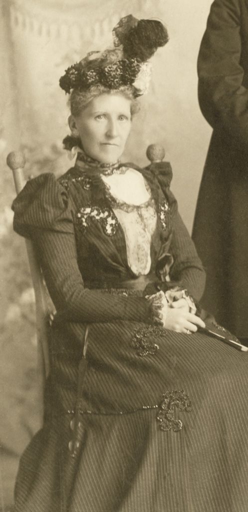 portrait of Pauline Lane, sepia photograph showing a seated woman in a formal dress and hat