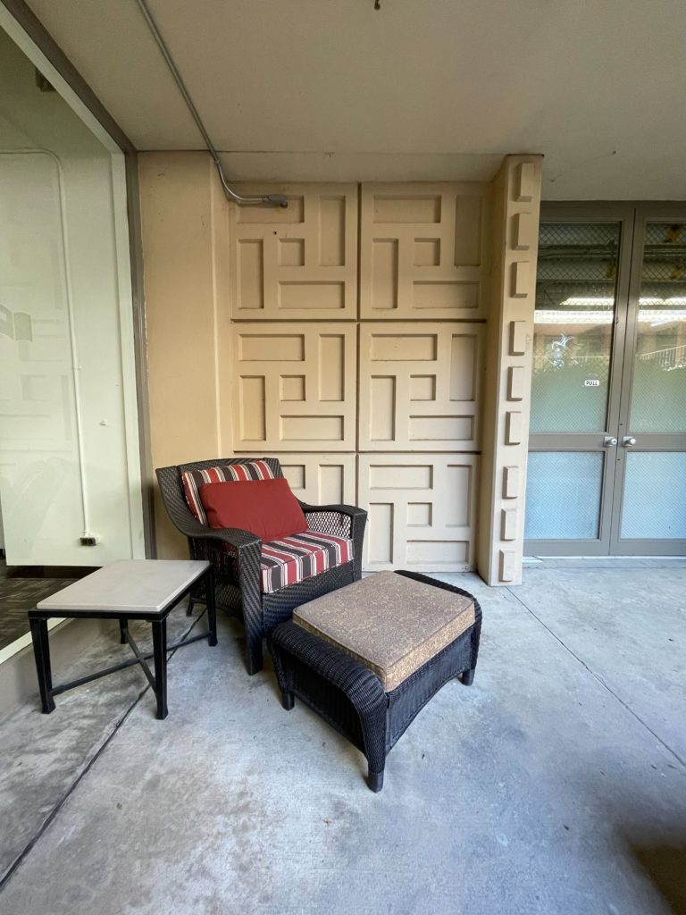 Armchair and ottoman with side table in the library courtyard